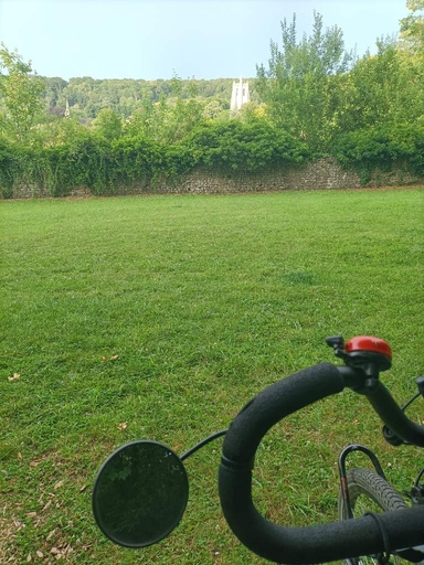 paysage avec une abbaye en arrière plan. Devant un bout de guidon de velo