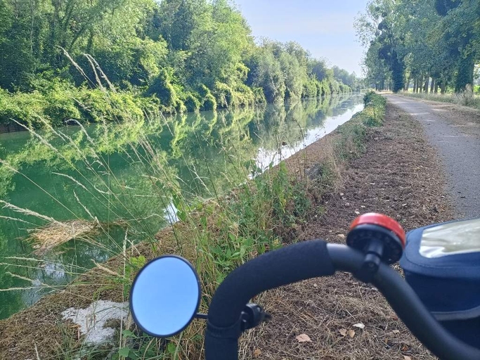 canal bordé d'arbre avec son chemin de halage. Devant un bout de guidon de velo